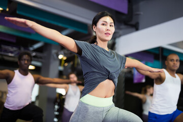 Fototapeta na wymiar Portrait of sporty woman doing cardio exercises training with step platform at fitness center
