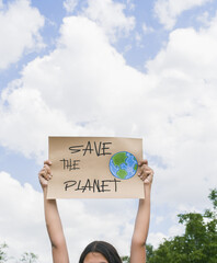 Young Hispanic girl raises a sign protesting for global warming