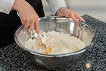 the cook is kneading the dough. flour and egg