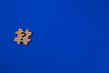 Question mark on jigsaw puzzles isolated with blue background.