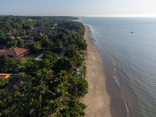 Wonderful city in the middle of the forest and Atlantic ocean with beautiful beach and low tide showing the corals - Cumuruxatiba, Bahia, Brazil - aerial drone view.