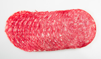 Thin salami sausage slices on white background, view from above