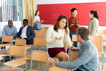 Adult students lively chatting while enjoying free time in class