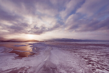 Frozen surface of Baikal lake at sunset.