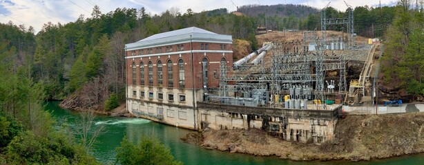 Fototapeta na wymiar Old brick electric power plant on the river