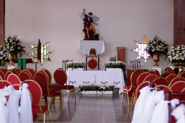 interior of a church decorated for the first communion in the background the altar with San Miguel Arcangel