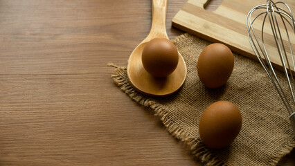 Fresh and raw chicken eggs on a wooden background.