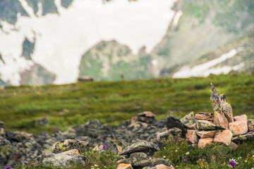 Stone pyramids of cobblestones on top of mountain under thick clouds overlooking valley. Landmark for navigating in fog in highlands. Meditation to strengthen strength of spirit.