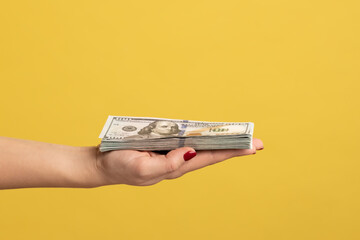 Side view closeup of woman hand showing fan of dollar banknotes, arm holding cash, lot of money and...