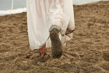 girl's feet in the sand and white dress
