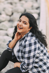 Street portrait of an Indian girl in a plaid shirt outdoors