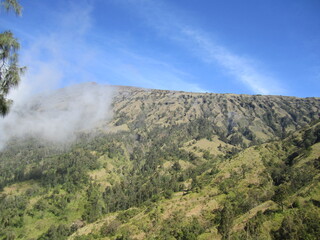 Mount Rinjani, the second highest volcano mountain in Indonesia, located in Lombok Island. A mountain with a beautiful crater lake called Segara Anak during a sunny day with blue sky.