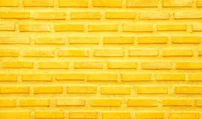 Brick wall painted with yellow paint pastel bright tone texture background.