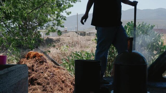 man preparing the copper alembic for the distillation of mezcal