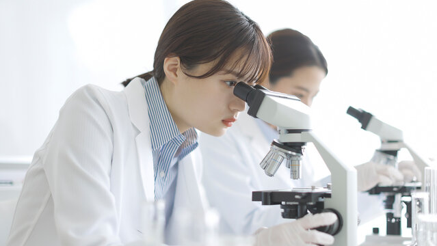 顕微鏡を覗く白衣の女性