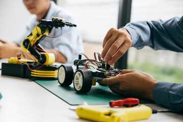 Asian teenager doing robot project in science classroom. technology of robotics programing and STEM...