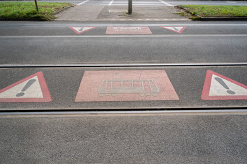Danger symbols on the ground between tram rails for pedestrians at a tram crossing