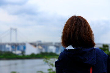 海と都市風景を眺めている女性