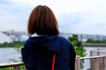 海と都市風景を眺めている女性