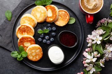 Cottage pancakes with jam, sour cream and berries