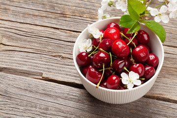 Ripe cherry in bowl with cherry blossom