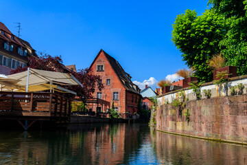 Fototapeta na wymiar Traditional colourful half-timbered houses alongside the Lauch river in Little Venice district in Colmar, Alsace, France