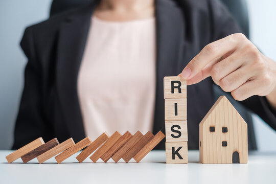 Businessman stop falling wooden blocks and protect house model. Crisis, fall Business, Risk, Economic recession, Developer, Real Estate and Property concept