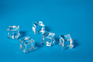 Clear ice cubes for cooling drinks on a blue background.