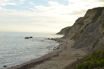 pretty sunset on the beach with sharp rocky cliffs and curving coastline new England beauty