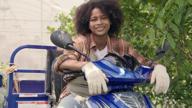 Happy children girl farmer sitting on tricycle in hydroponics farm, Biotechnology kid with Skylab motorcycle at vegetable farm, market transportation