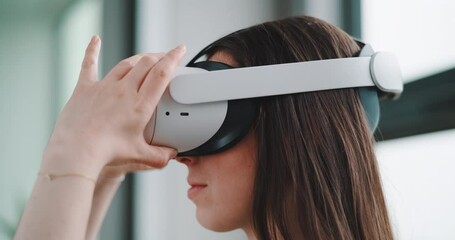 Close up of young woman from left side putting on vr goggles - Powered by Adobe