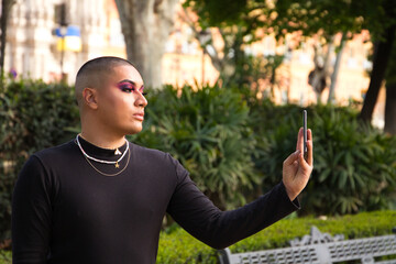 Non-binary and young person from South America is on holiday in Europe, the person is make up and wearing black clothes. He is visiting the city and takes pictures with his mobile phone. Travel