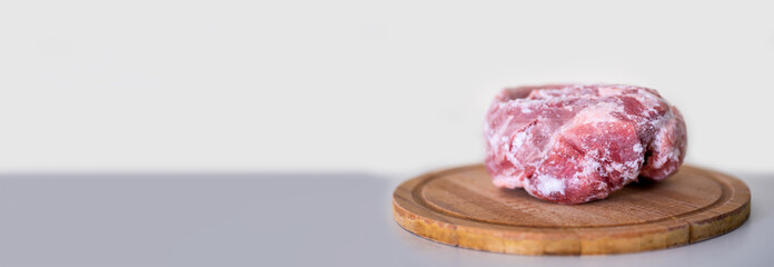Frozen pork meat on a cutting board. copy space.