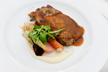 Grilled sliced beef steak with green salad on a plate.