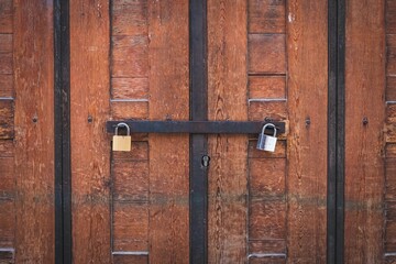  two padlocks on wooden door, closed gate
