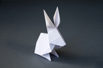 White paper rabbit origami isolated on a grey background
