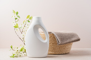 Eco-friendly washing white bottle and Clean towel in wicker basket. Eco-friendly laundry concept - obrazy, fototapety, plakaty