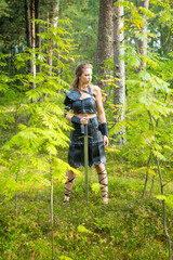 mediaeval female barbarian wearing leather skirt, vambrace, plastron and brassart with heavy sword...