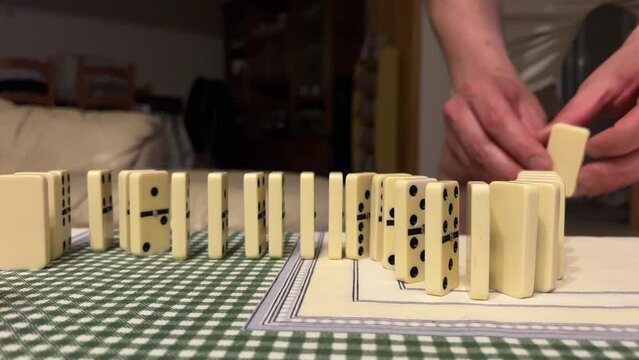 playing dominoes the hands of a girl and the hands of a man build dominoes. High quality 4k footage