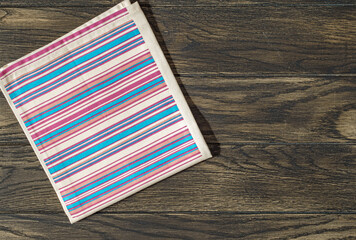 Striped napkin from left side of wooden table top view. Food background