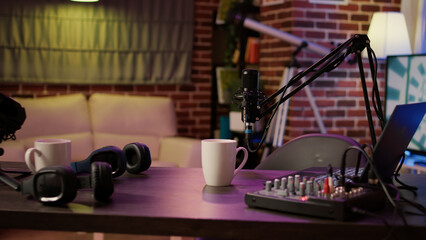 Nobody in podcast home studio with microphone boom arm and audio recording professional mixer on...