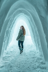 Woman walking in the entrance from an igloo.