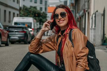 Obraz premium relaxed red-haired tourist woman with phone and backpack on the street
