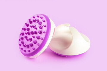 Hand massager with silicone spikes for anti-cellulite massage procedure isolated on violet background. Massage brush tool for problem body zone, self-care, health care, body therapy. - obrazy, fototapety, plakaty