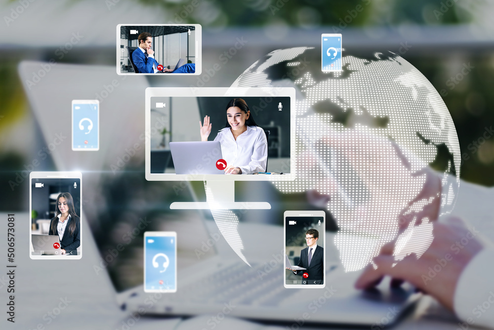 Poster hands at workplace with devices and creative globe map with computer screens and creative video conference call between attractive young european business people. Blurry background.