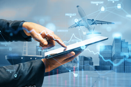 Close up of businessman hand pointing at tablet or smartphone with abstract glowing shipping hologram on dock with transport background. Export, logistics and freight concept. Double exposure.