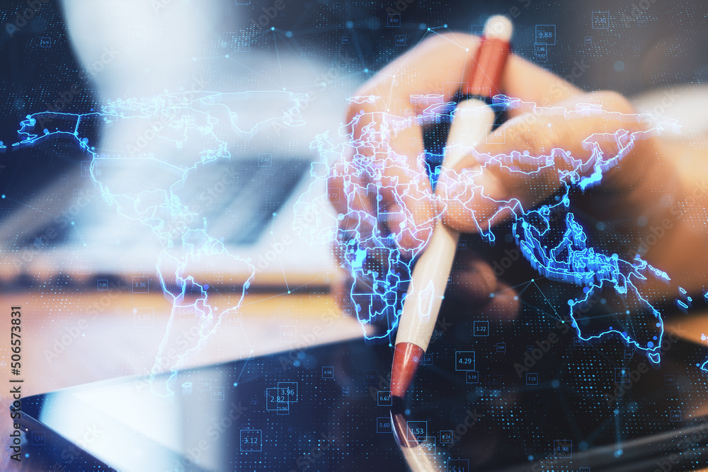 Poster close up of hands using digital tablet with pen and laptop with glowing blue map hologram and digita