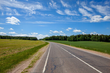 Fototapeta na wymiar paved highway with blue sky and clouds
