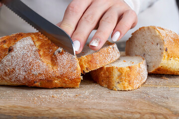 a fresh soft loaf of bread cut into pieces with a knife