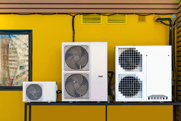 Air conditioners, compressors, wall mount on the background of the wall of the house, installation,...